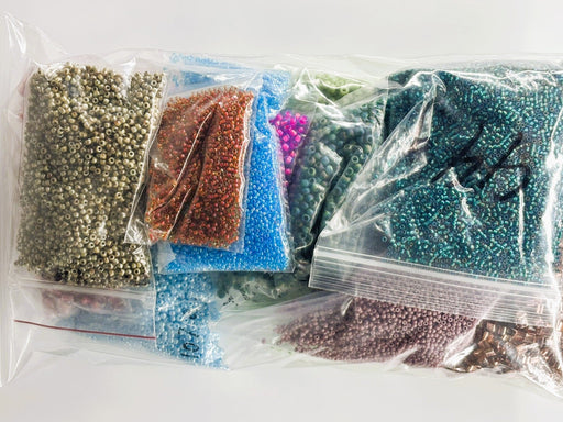 Assorted beads in clear plastic bags on a white background
