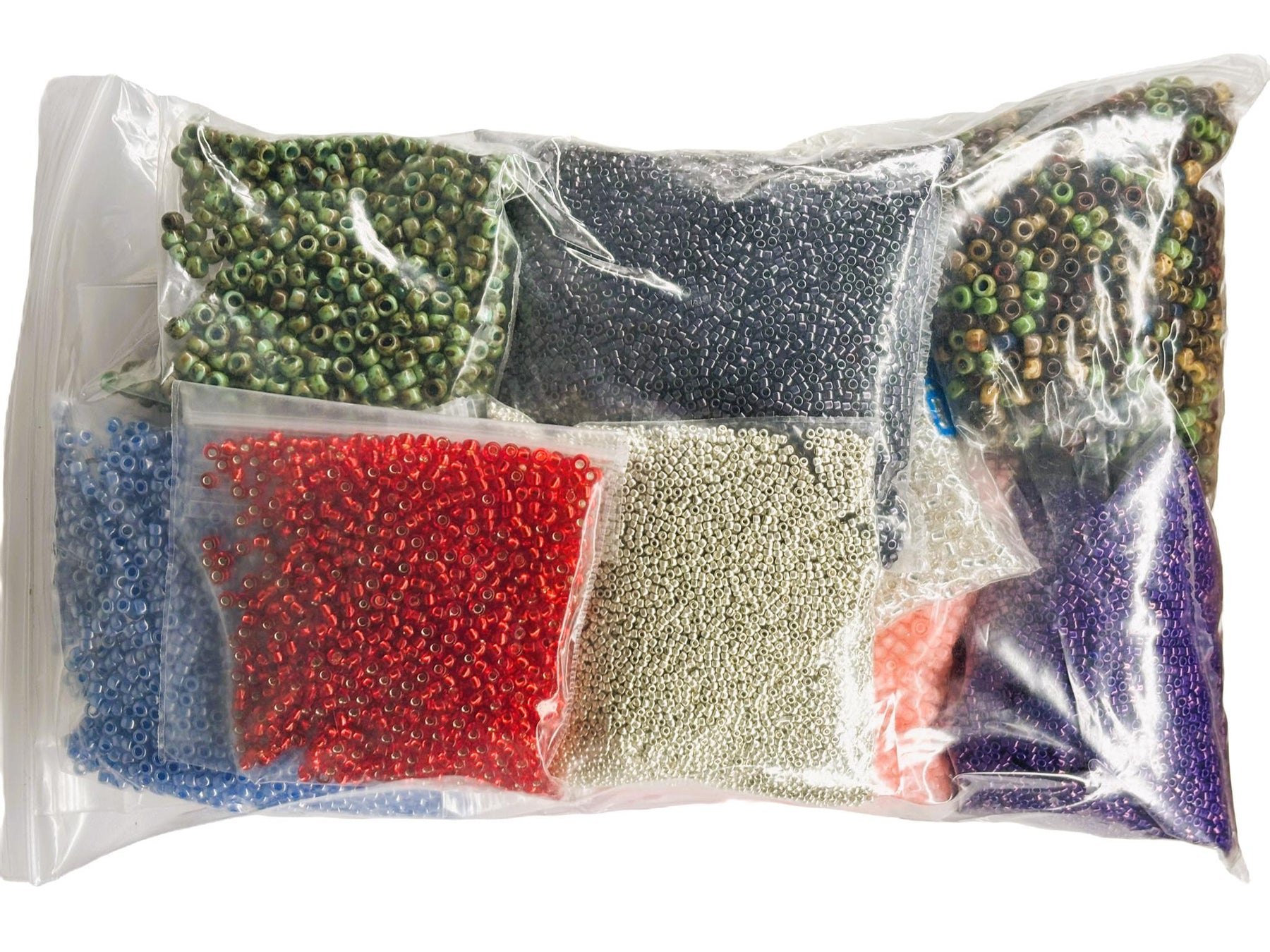 Assorted colored beads in a clear plastic bag on a white background
